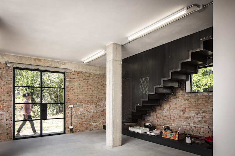 Pavimenti in cemento, infissi neri dallo stile industriale, parapetti in lamiera forata, arredi ricercati e vecchi oggetti di recupero creano spazi ancora più personalizzati in sintonia con le opere esposte e con l’architettura rurale in mattoni a vista © Fabio Mantovani