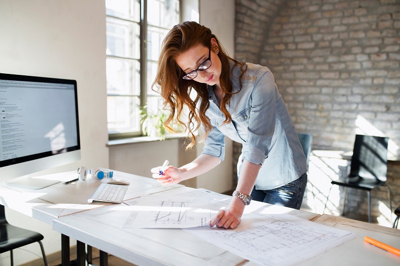 Portrait of young female architect working on project